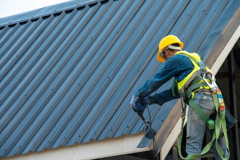 A picture of a person working on a metal roof services
