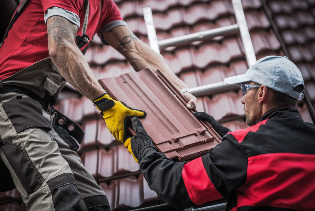 An image of two persons working on a roofing services