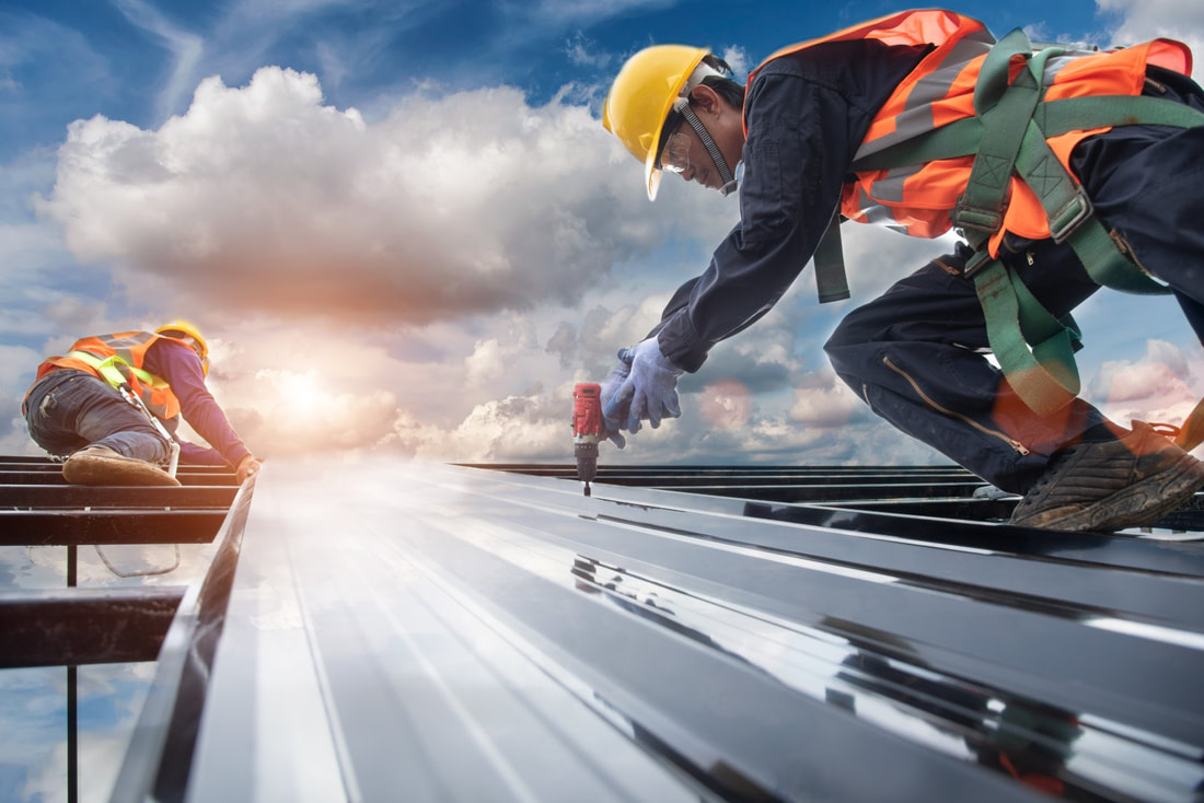 An image of two persons working on a metal roofing service